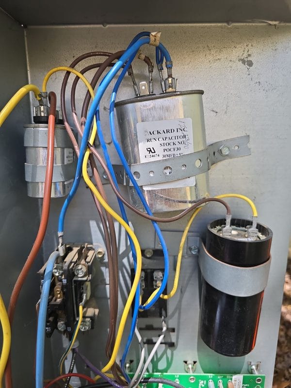 Open ac condenser electrical cabinet showing capacitor contactor and control board