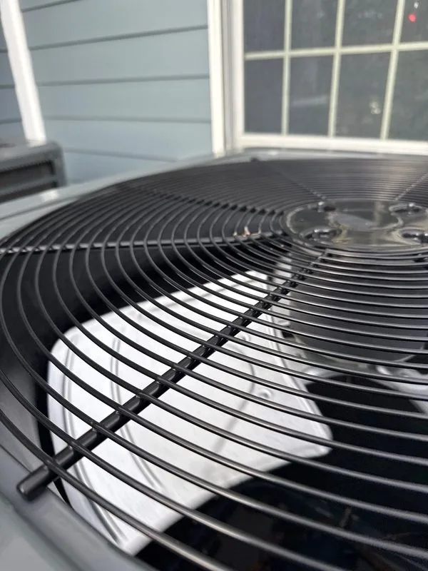 Clean ac condenser fan grille after professional maintenance service