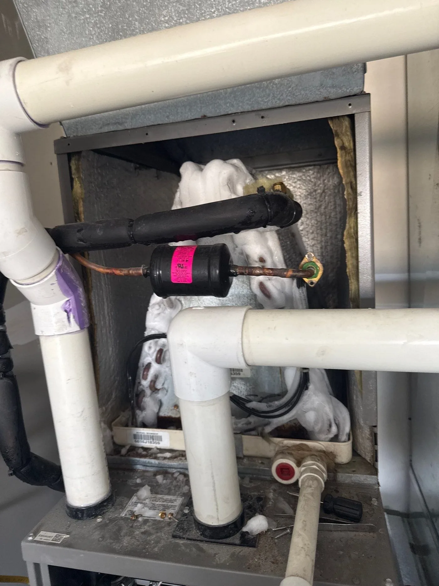 Open air handler showing severely frozen evaporator coil during ac repair diagnosis