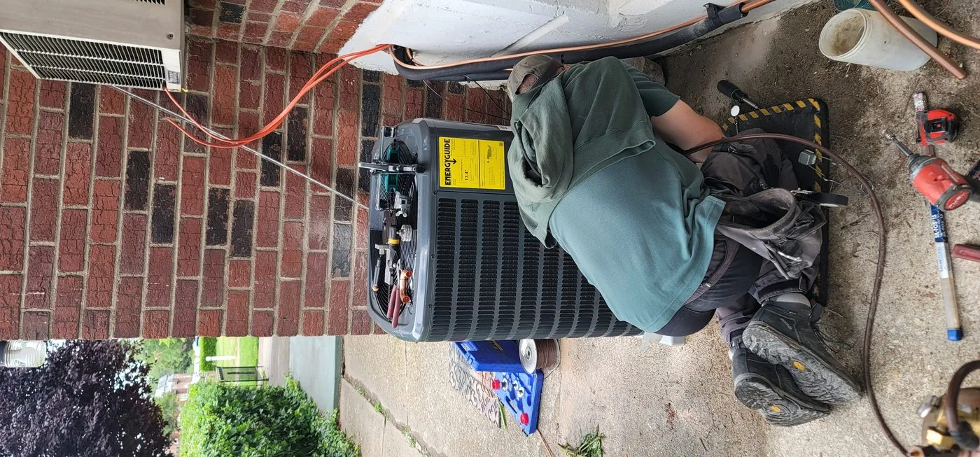Technician repairing residential air conditioning equipment