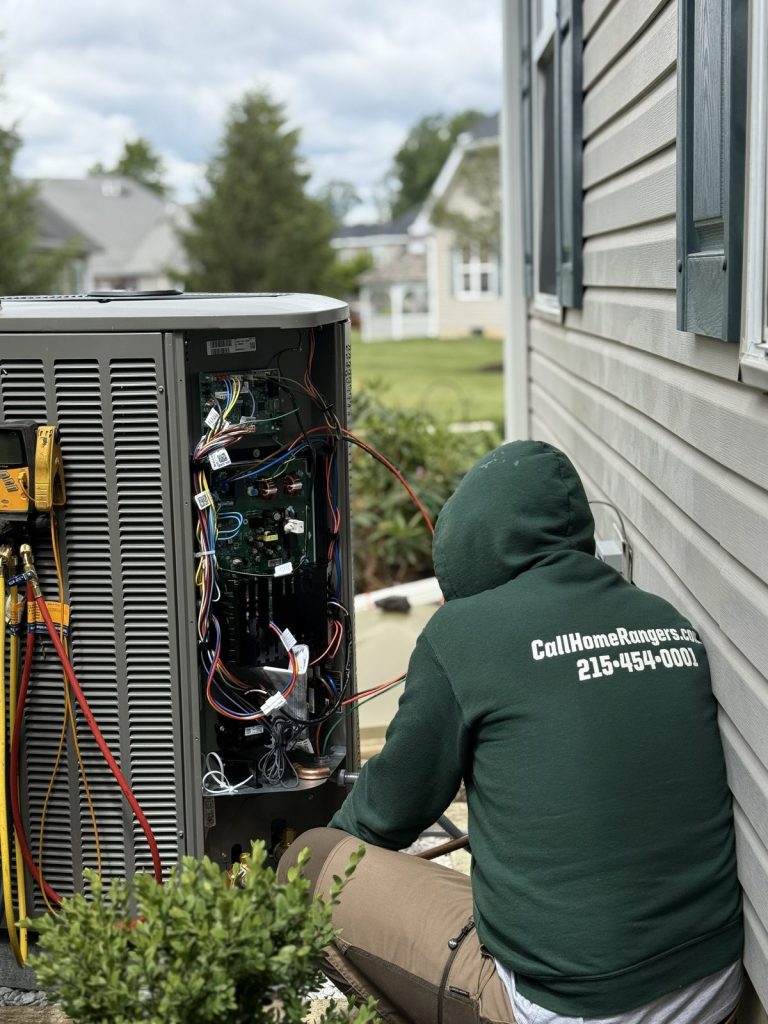 Home rangers heat pump repair photo showing a technician diagnosing an outdoor unit control board