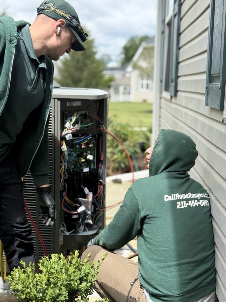 Home rangers hvac repair photo showing technicians diagnosing an outdoor air conditioning system in montgomery county