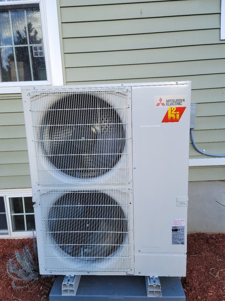Home rangers heat pump installation photo showing a mitsubishi hyper-heat outdoor unit beside a home