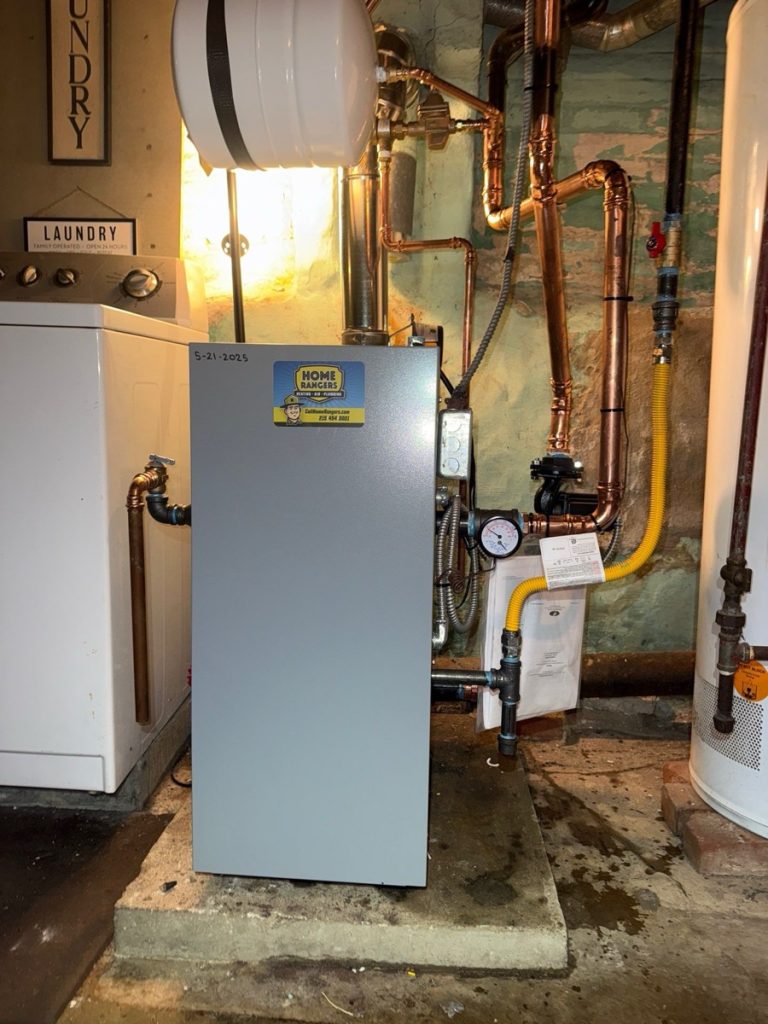 Home rangers boiler installation photo showing a clean weil-mclain boiler with copper hydronic piping in a basement laundry area